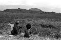 A young boy and an old man watch the distant war