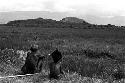 A young boy and an old man watch the distant war