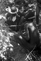 Men preparing for an Etai; whitening the decorations on their spears