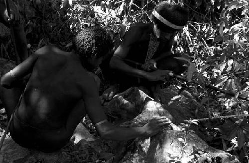 Men preparing for an Etai; whitening the decorations on their spears