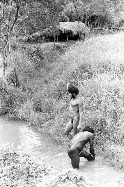 Men washing in an irrigation ditch