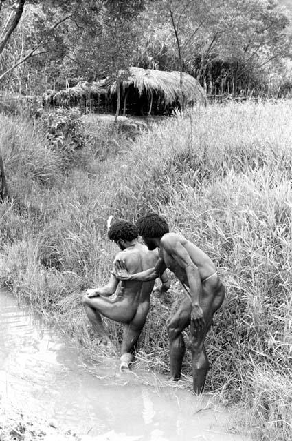 Men washing in an irrigation ditch