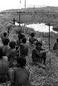 Men sitting by a pond on the Tokolik