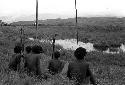 Men sitting by a pond on the Tokolik