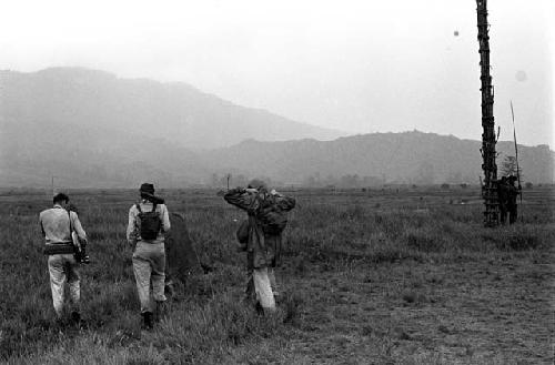 Robert Gardner, Karl Heider, and Peter Matthiessen, and others return home in the rain after a battle