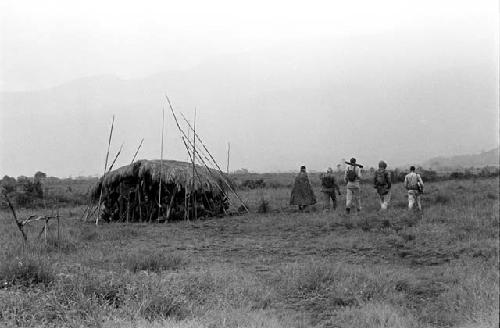 Robert Gardner, Karl Heider, and Peter Matthiessen return home in the rain after a battle