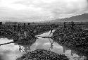 Men walking on a path by an irrigation ditch