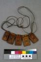 Necklet of five decorated leather amulet packets strung on a leather cord