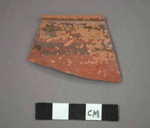 Ceramic rim sherd, red ware, black painted designs below lipped rim