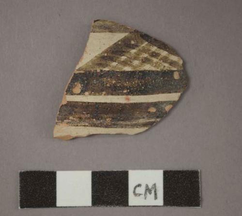 Ceramic body sherd, black painted designs on white on exterior