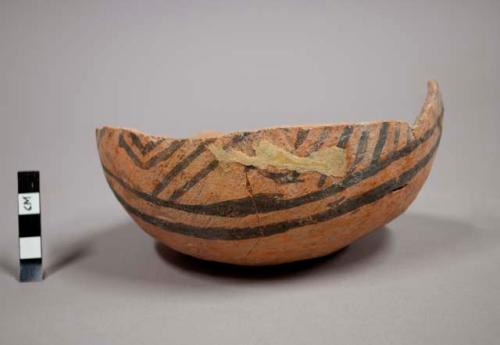 Part of jeddito black-on-orange pottery jar with broken edge ground down to form