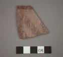 Ceramic rim sherd of bowl, incised texture and red painted designs on exterior