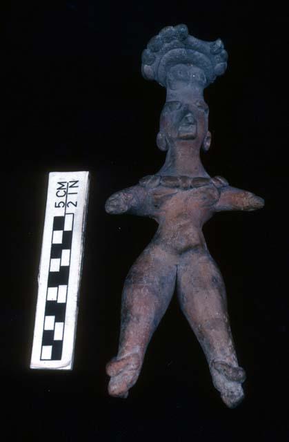 Clay figurine, type "C", wearing anklets, bead necklace, ear caps and a nose pe