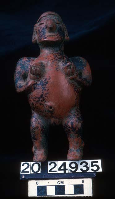 Effigy rattle with suspension holes through neck depicting female holding breast