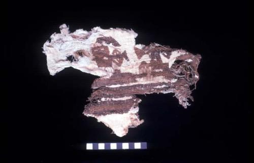 Brown and white textile fragment with cotton batting from Site 128