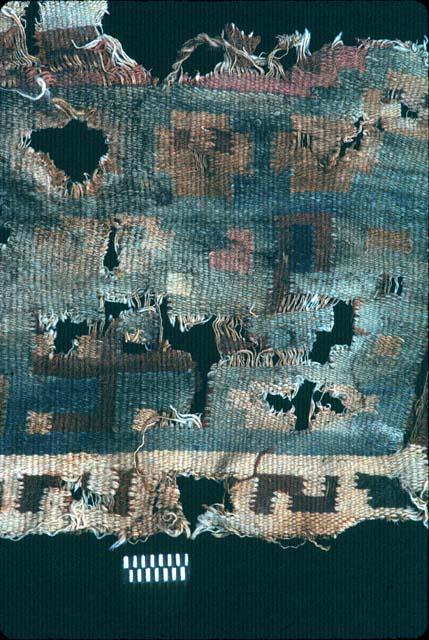 Textile fragment with faces and S's from Site 120