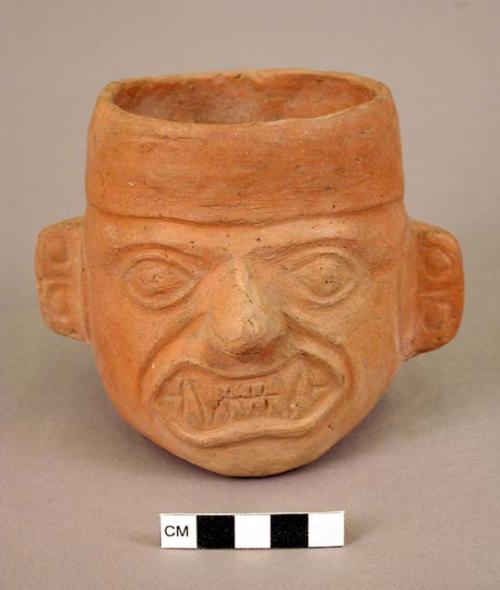 Ceramic cup, human effigy, molded face, fangs, earplugs