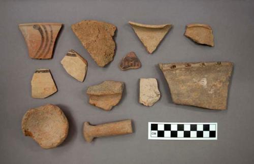 Ceramic body or rim or base sherds and one handle fragment, one sherd has designs both incised and in relief, some sherds have painted designs