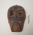 Carved and painted wooden mask with projecting piece on back