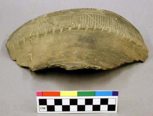 Ceramic rim sherd of a jar, incised, linear design, brown.