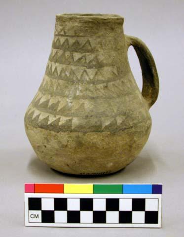 Pitcher. Black on white ware showing parallel rows of "saw teeth"