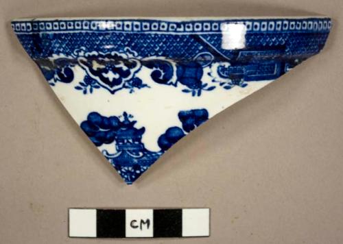 Rim sherd, blue and white floral design with house, from a dish.