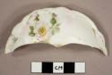 One rim sherd from a lid, floral pattern with gold accents. white glaze background