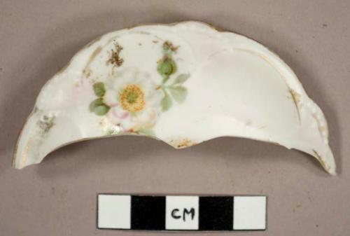 One rim sherd from a lid, floral pattern with gold accents. white glaze background