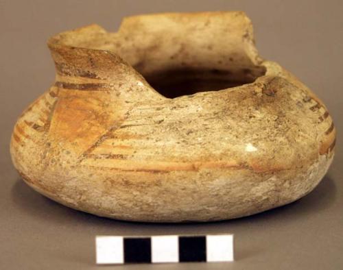 Ceramic jar, red on buff exterior, rim sherds missing, flared neck, flat base