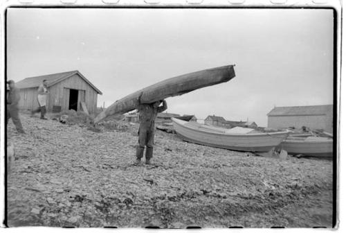 Man carrying kayak over shoulder