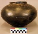 Pottery jar. Flat base, globular body, short and straight rim, polished black