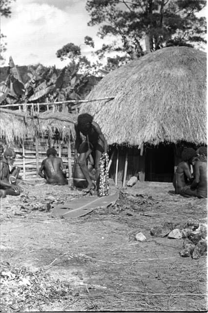 Men examining cowrie shells