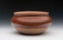 Pottery jar with recurved rim. Flattened base, hemispherical. Red polished sli