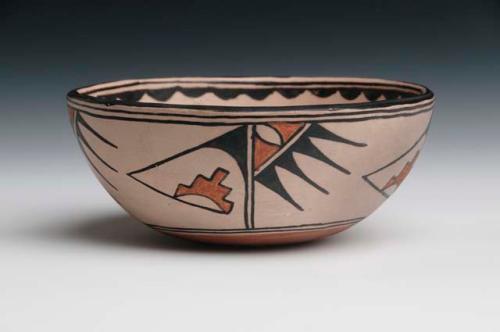 Pottery bowl. Shallow, cream slip with black and orange design on outside. 6.5
