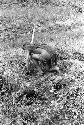 Woman bending to clear grass