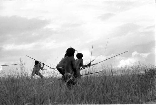 Men crouching from arrows