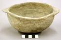 Complete ceramic bowl, two flat protrusions on rim, plain