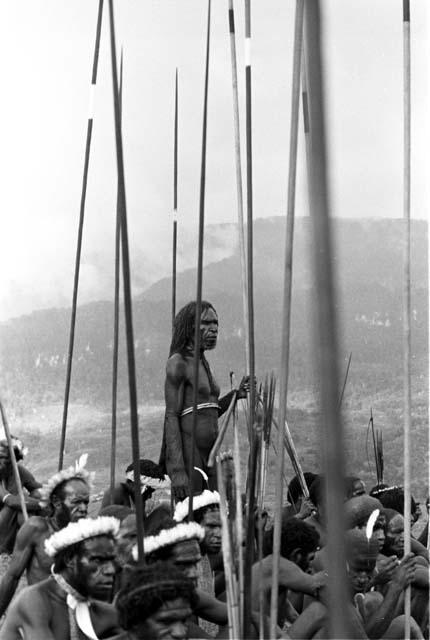 Polik standing amidst his warriors