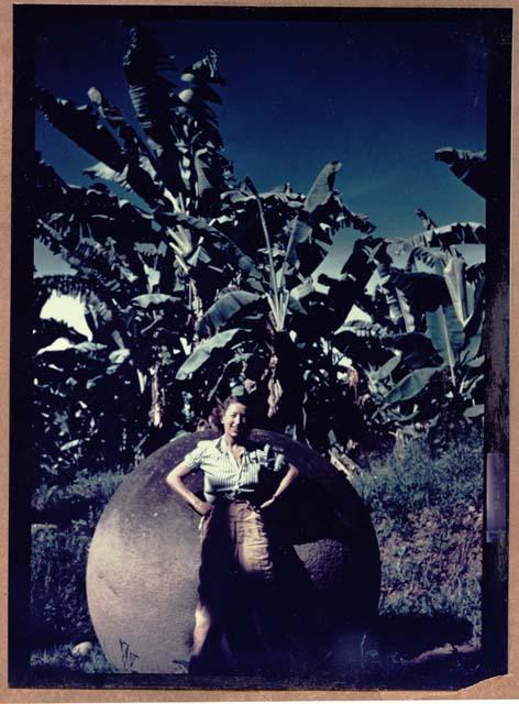 Woman standing in front of stone ball