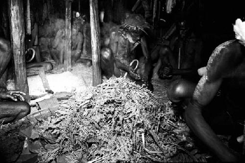 making tipats in front of honai, pile of ferns in front of the fireplace