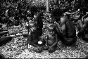 2 little children next to their father who is eating pig