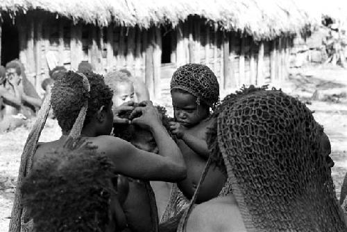 children and a woman lousing another child