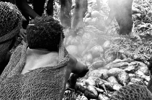 hands in the haksé digging out the hot potatoes