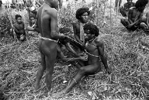 a man begins to patch the cuts that were made on Eken Buken's stomach