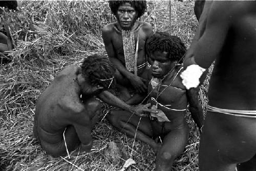 a man begins to patch the cuts that were made on Eken Buken's stomach