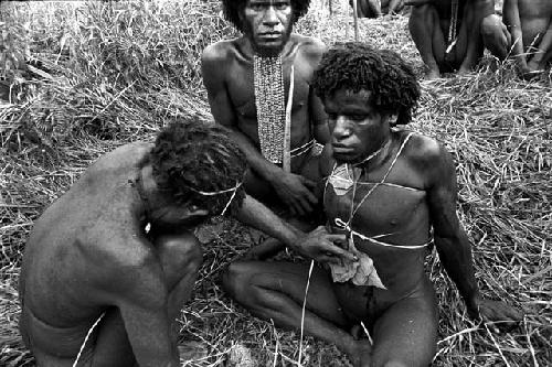 a man begins to patch the cuts that were made on Eken Buken's stomach