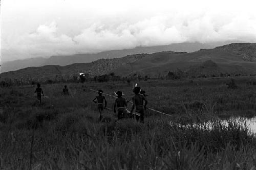 men standing up running towards the Warabara