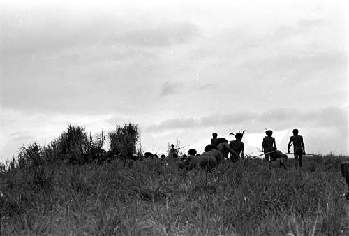 warriors crouching trying to stay hidden while working their way up to the top of the knoll of the Warabara