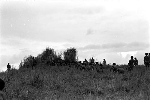 warriors crouching trying to stay hidden while working their way up to the top of the knoll of the Warabara