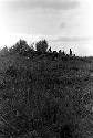 warriors crouching trying to stay hidden while working their way up to the top of the knoll of the Warabara